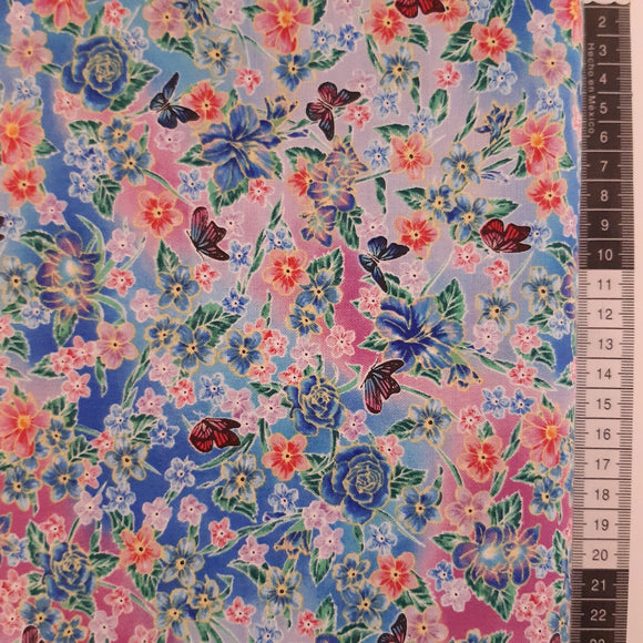 Patchwork stof, blå og pink meleret med blomster og sommerfugle.