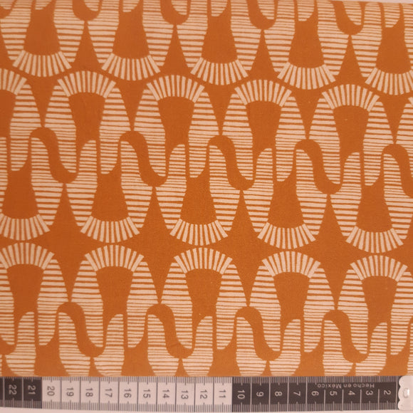 Patchwork stof, brændt orange med lyst mønster.