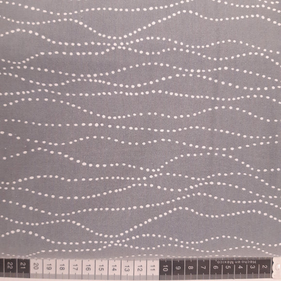 Patchwork stof, grå med lyse prikker der bølger i rækker