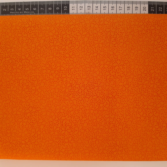 Patchwork stof, orange med mini prikker der danner mønster.