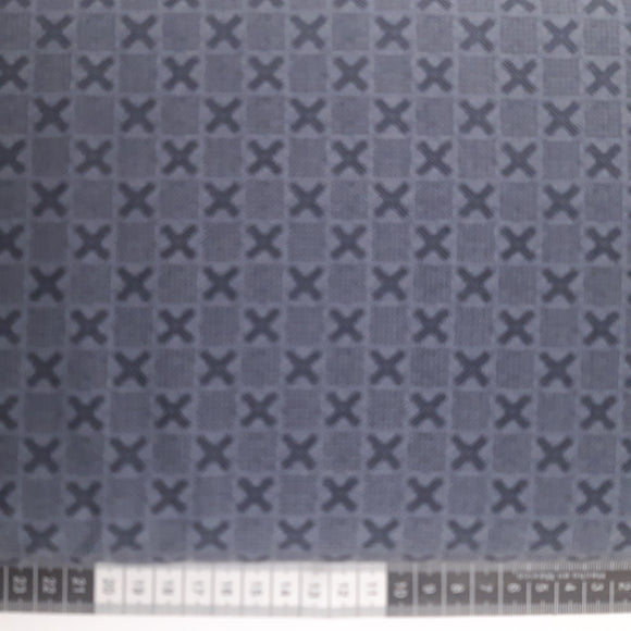 Patchwork stof, grå med tern af prikker og krydser.