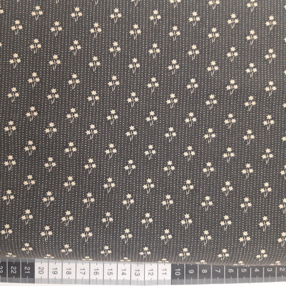 Patchwork stof, mørk grå med små prikker og stjerne blomster.