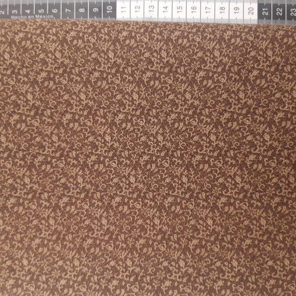 Patchwork stof, brun med lysere gnidret mønster.