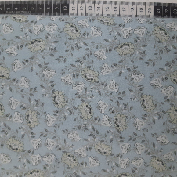 Patchwork stof, lyseblå med grønlige blomster og bladranker.