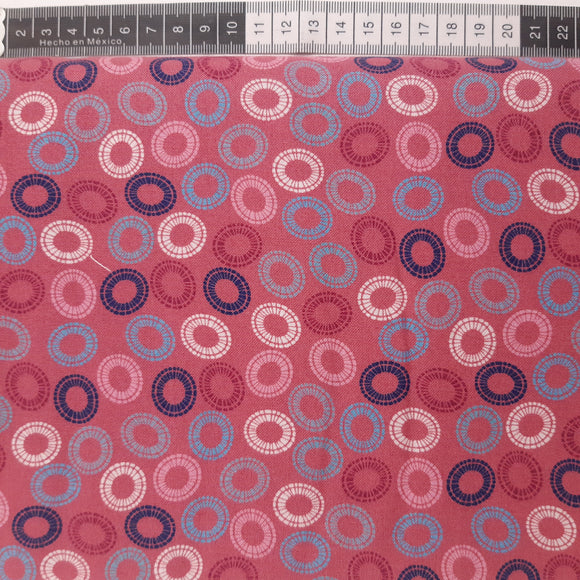 Patchwork stof, støvet pink med blå og hvide ovaler.