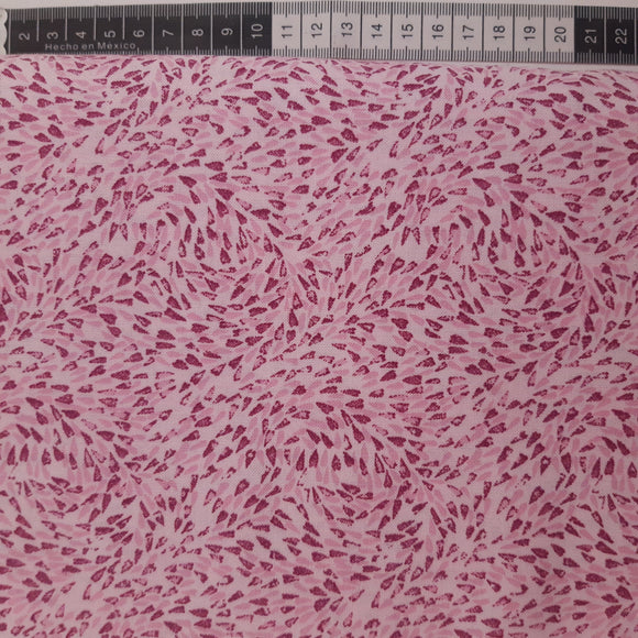 Patchwork stof, lyserød med små pink dråber der snurrer rundt.