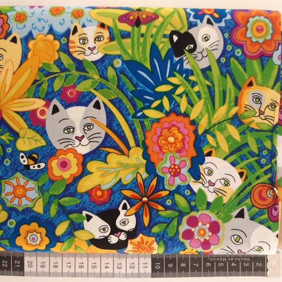 Patchwork stof, blå bund og katte hoveder gemt mellem blomster
