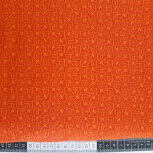 Patchwork stof, klar orangerød med lysere grafisk mønster