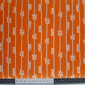 Patchwork stof, orange med hvidt grafisk mønster