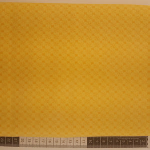 Patchwork stof, gul med mini blomster og streger der danner firkanter.