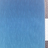 Patchwork stof, tone i tone med farveskift fra lys blå i midten og til mørk blå i siderne.