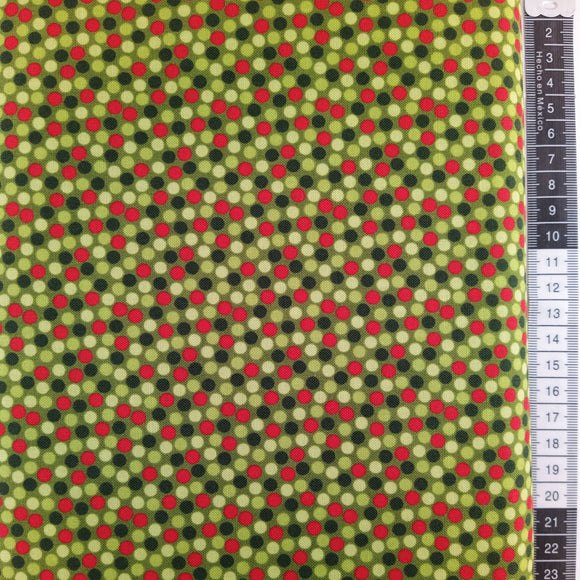 Patchwork stof, mørk army grøn bund ned små røde og flerefavet grønne prikker.