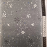 Patchwork stof, ombrea bund i grå nuancer med hvide, sort og lyseblå snefnug