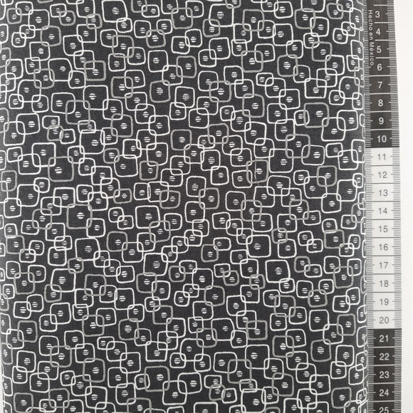 Patchwork stof, sort bund med småt mønstret grafisk design.