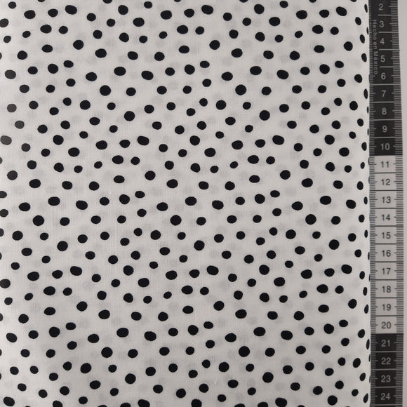Patchwork stof, hvid bund med små sorte forskellige former prikker.