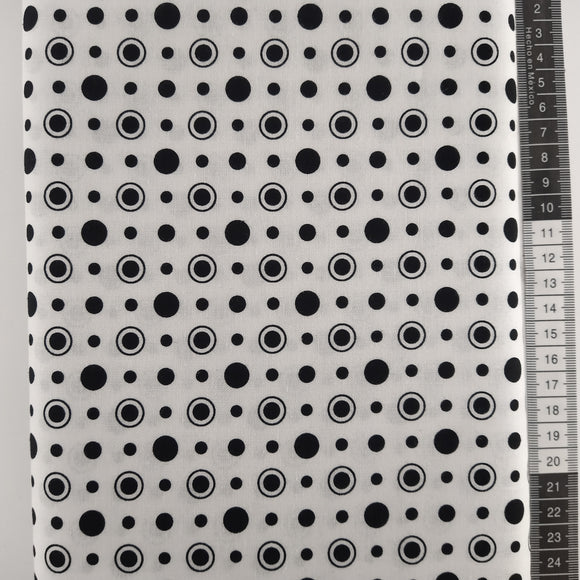 Patchwork stof, hvid bund med forskellige størrelse sorte cirkler og prikker.