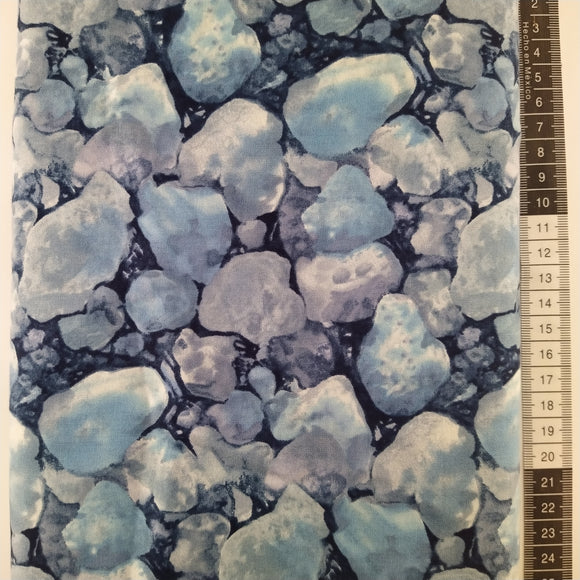 Patchwork stof, mørkeblå bund med store flotte sten / grus med vandfarve effekt i blå og grå farver.