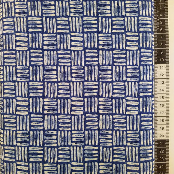 Patchwork stof, blå bund med hvide og blålige striber som sidder i et kvadratisk mønster.