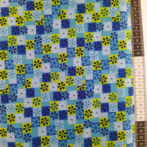 Patchwork stof, lyseblå bund med små firkanter med 3 forskellige farver med små blomster.