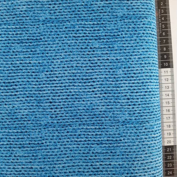 Patchwork stof, med en flot klar lyseblå farve og lidt mørkeblå. Det ligne som det er garn som er viklet omkring rulle.