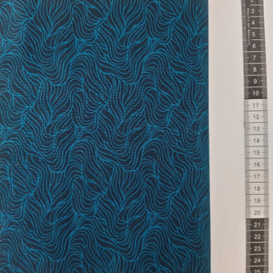 Patchwork stof, dyb mørkeblå bund med stort turkis mønstret med blå bølgende linjer.