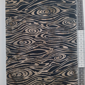 Patchwork stof, stort mønstret som ligner en træstamme med åretegninger i lysebrun og sort.