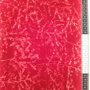 Patchwork stof, rød bund med et flot mønster som ligner grene fra grantræer i lys røde farver.