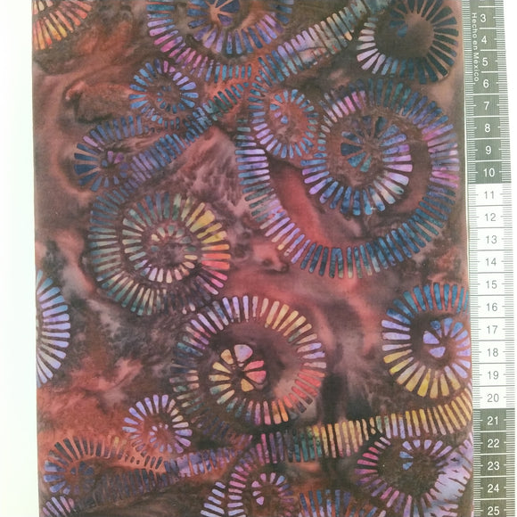 Patchwork stof, dyb mørk lilla og rød meleret bund med store spiraler i lilla nuancer.