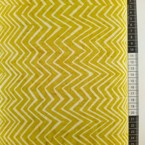 Patchwork stof, gulgrøn meleret bund med et stort zigzag mønster der går lodret.
