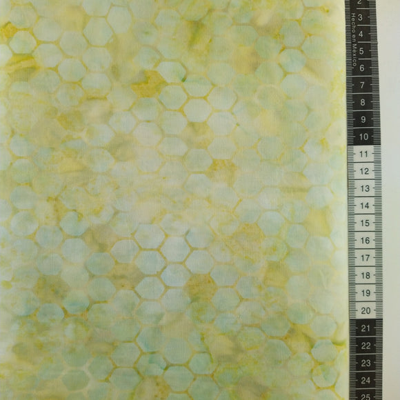 Patchwork stof, blågrøn med gul meleret bund med små mønstret design der ligner en bikube. Pas på de ikke stikker.