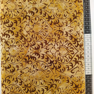 Patchwork stof, lys gul/brun meleret bund med stor mønstret design i de brune farver.