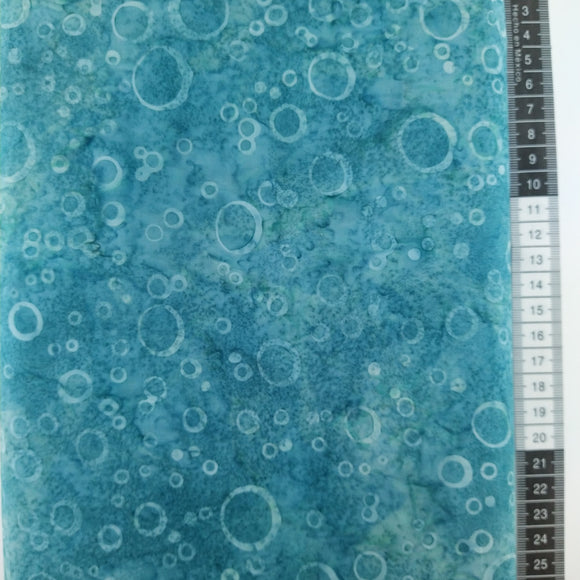 Patchwork stof, støvet blå/ grøn meleret bund med forskellige størrelser ringe.