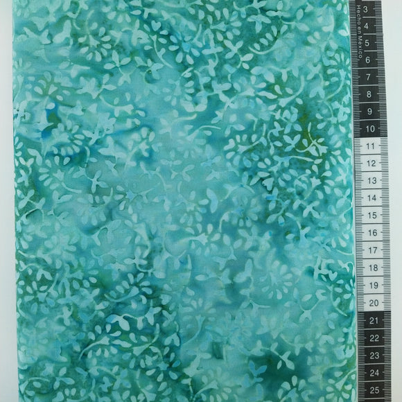 Patchwork stof,  blå/grøn meleret bund med små søde blomster på stilke som har blade i lysegrønne nuancer.