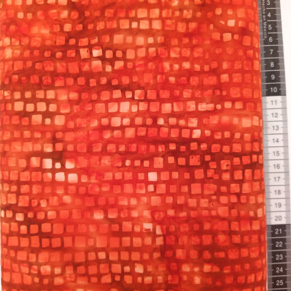 Patchwork stof, rød/gul meleret bund med forskellige størrelser lyse røde firkanter.