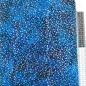Patchwork stof, mørkeblå meleret bund med små hvide og lyseblå splash prikker .